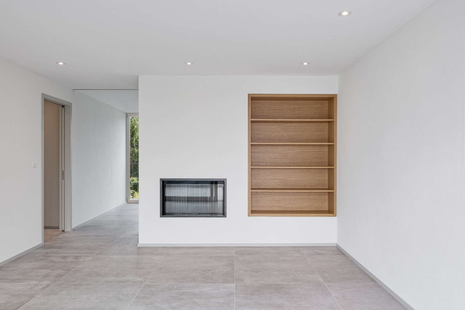 Orlando Architektur Neubau Mehrfamilienhaus Rigistrasse Pfäffikon ZH 5 Wohnen Cheminée Bücherregal