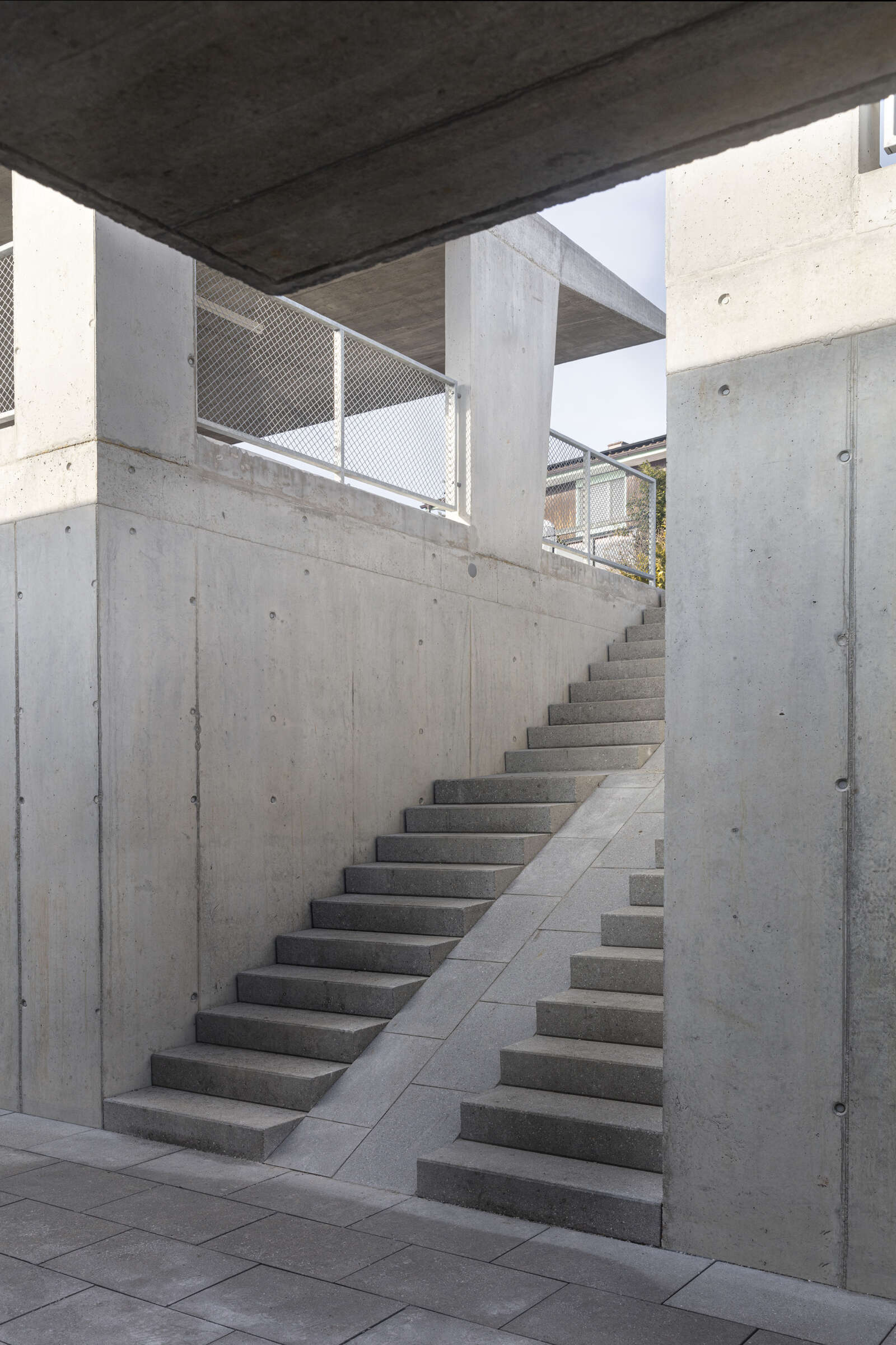 Orlando Architektur Neubau zwei Doppeleinfamilienhaeuser im Schueracher Waltenstein 12 Beton Eingang Hang Treppe