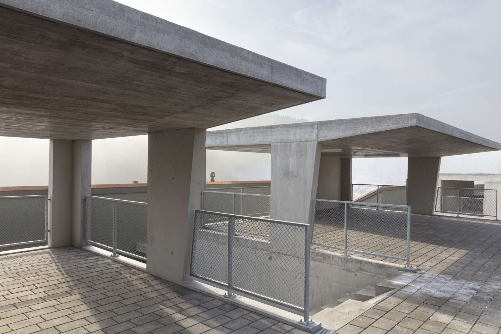 Orlando Architektur Neubau zwei Doppeleinfamilienhaeuser im Schueracher Waltenstein 14 Beton Carport Materialisierung