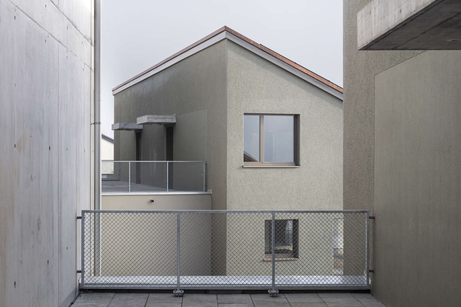 Orlando Architektur Neubau zwei Doppeleinfamilienhaeuser im Schueracher Waltenstein 4 Massivbau Hang Beton Putz Eingang